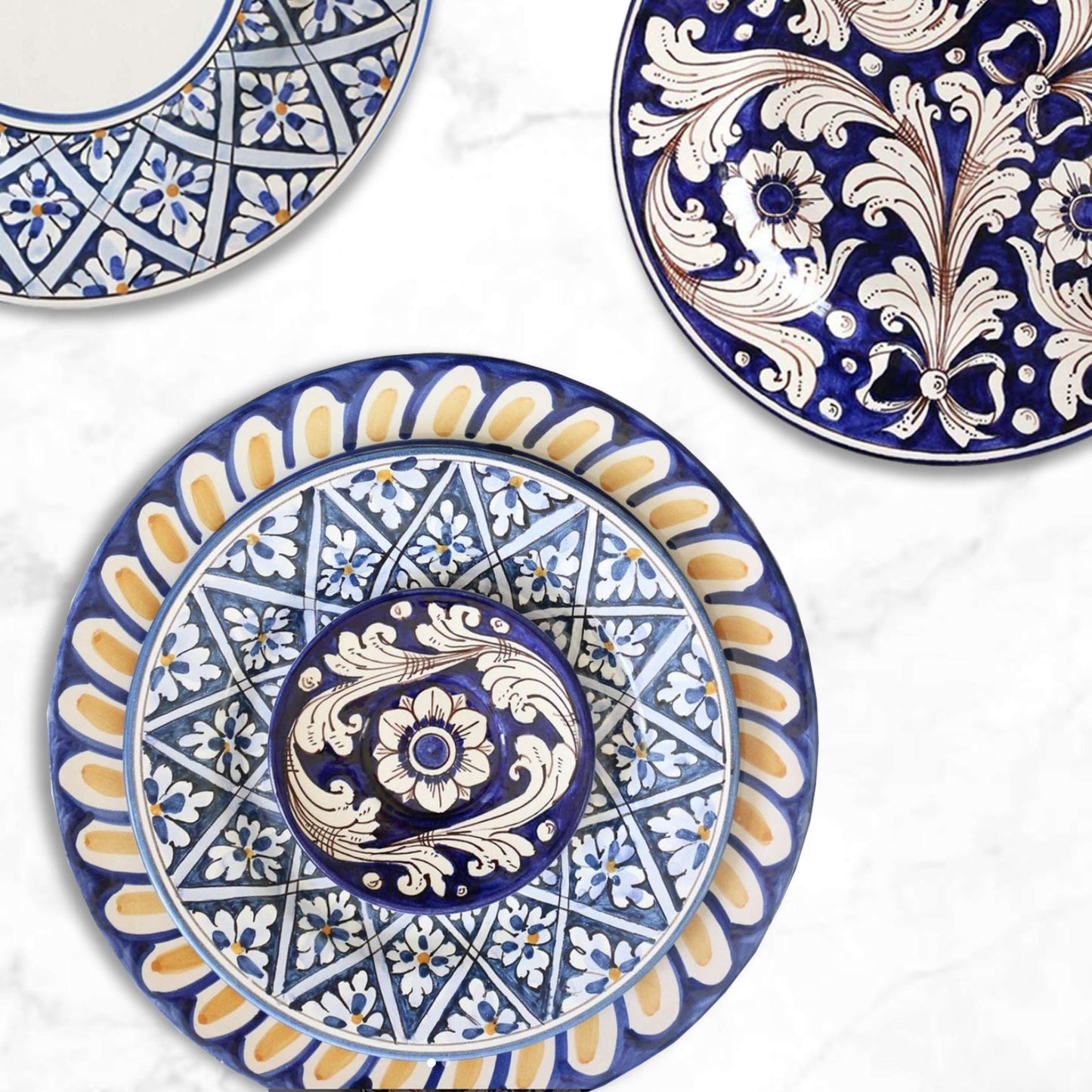 Colorful Sicily plates stacked for a vibrant tablescape, salad and dessert plates on top, dinner plate below, mix and match designs, handmade ceramic craftsmanship.