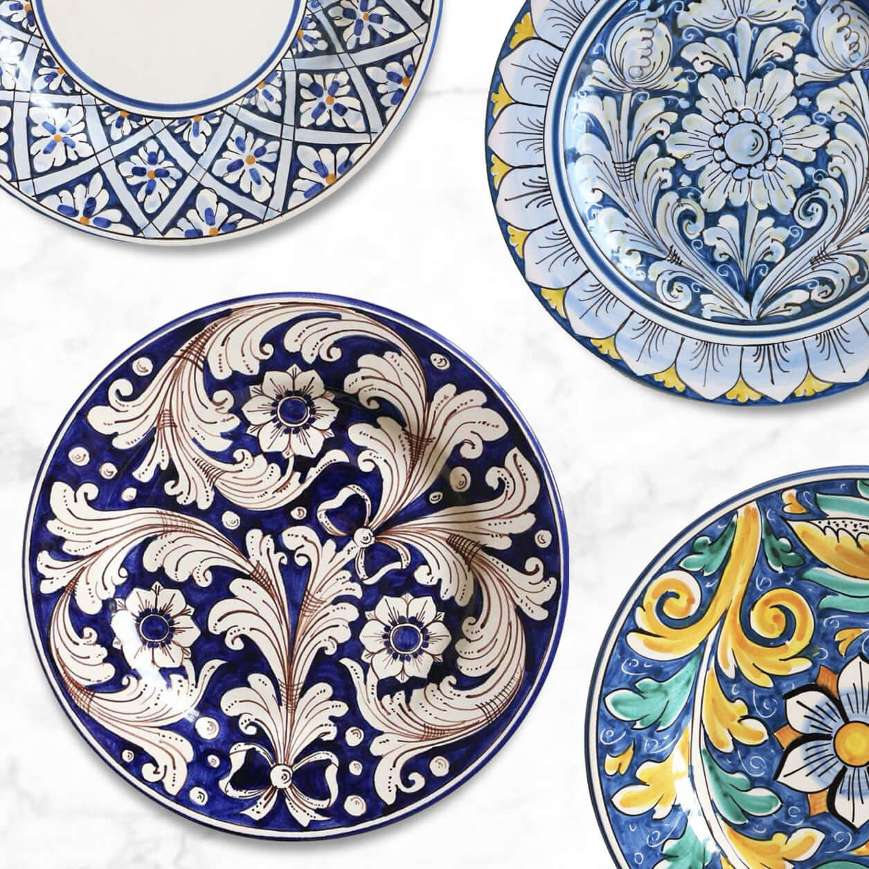 Handcrafted Sicilian ceramic dinner plates with intricate blue and yellow patterns, made in Caltagirone, Sicily.